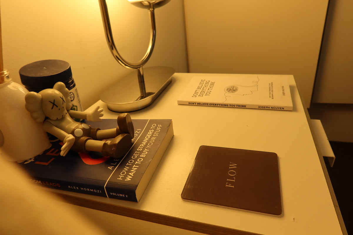A Flow stuck near the corner of a walnut bedside table